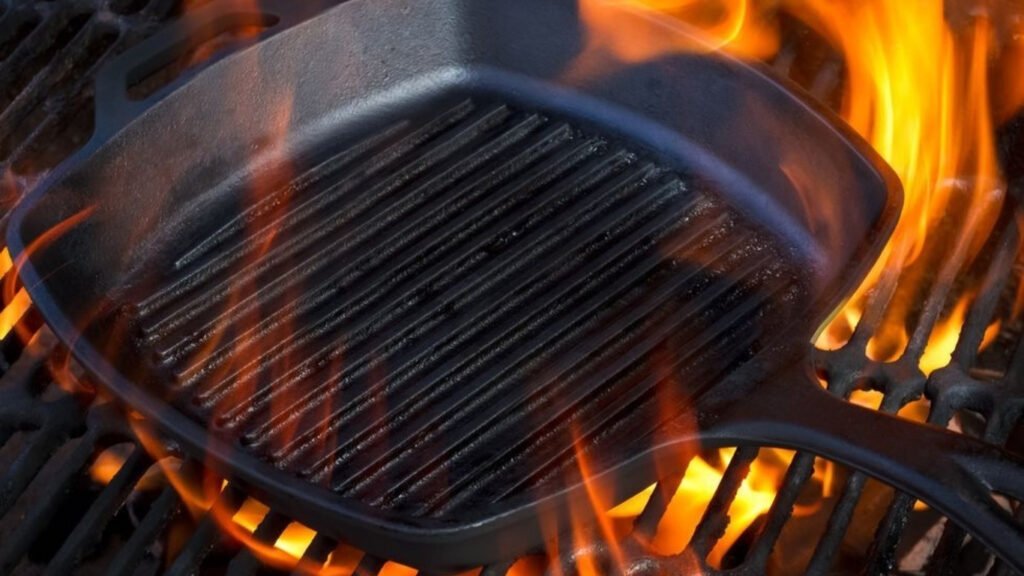 Cast iron skillet on a BBQ grill over open flame; high heat cooking with Castinex cast iron cookware